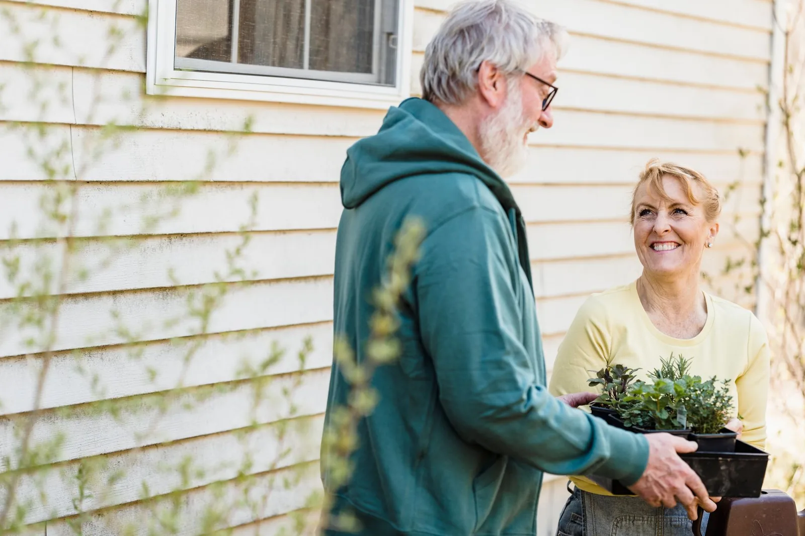 An older couple garden together in their own backyard.
