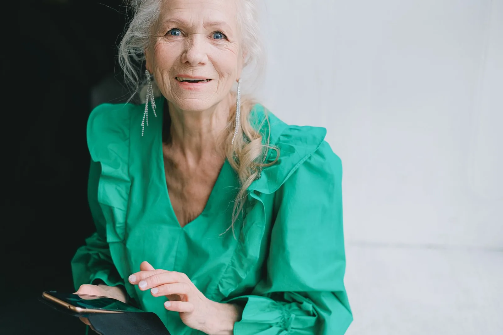 An older adult comfortably using a phone at home.