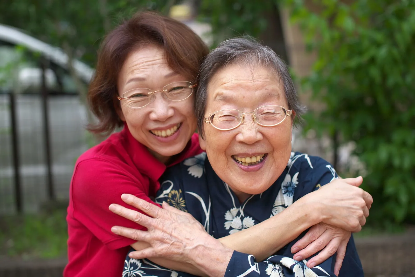 An adult daughter and her mother share a warm, reassured moment.