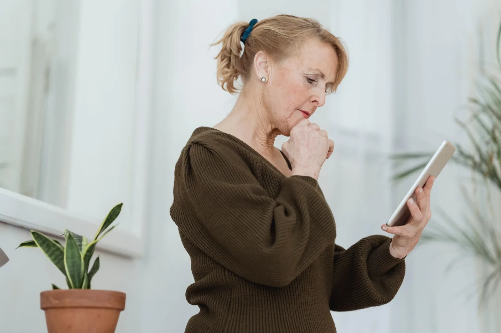 An adult daughter pauses to check her phone, a quiet moment of concern between calls.